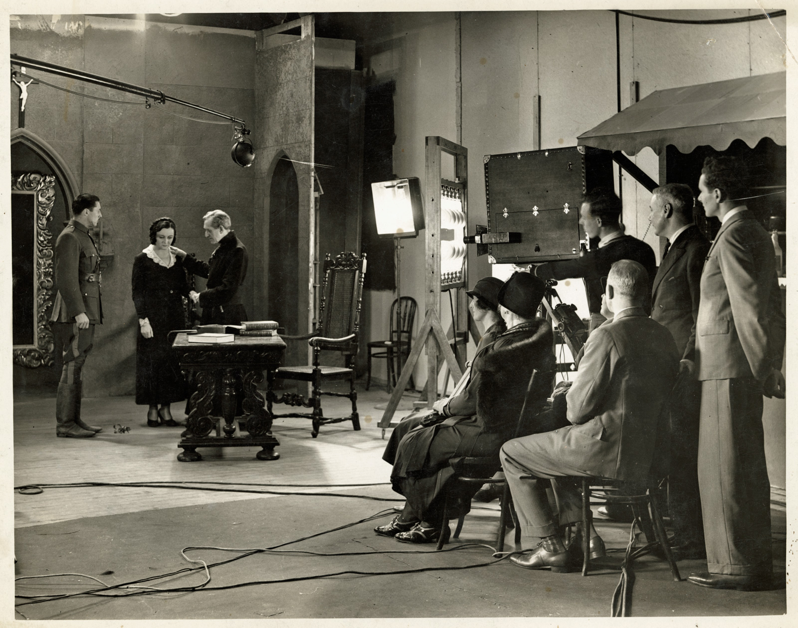 A film studio where you can see the director, crew and actors filming a scene.