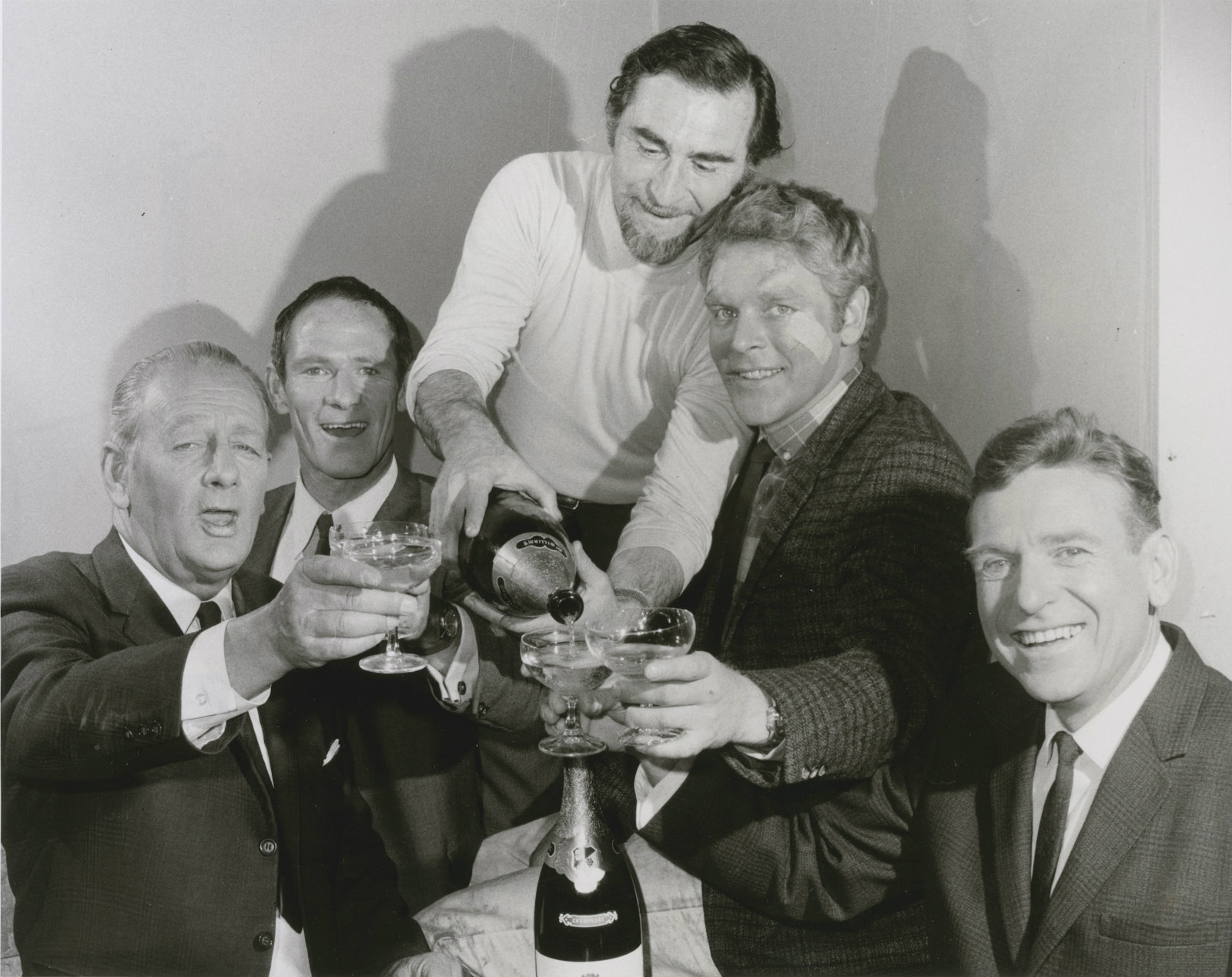Homicide director Director Alex Emanuel pours champagne for the main cast of Homicide - Alwyn Kurts, Norman Yemm, George Mallaby and Leonard Teale