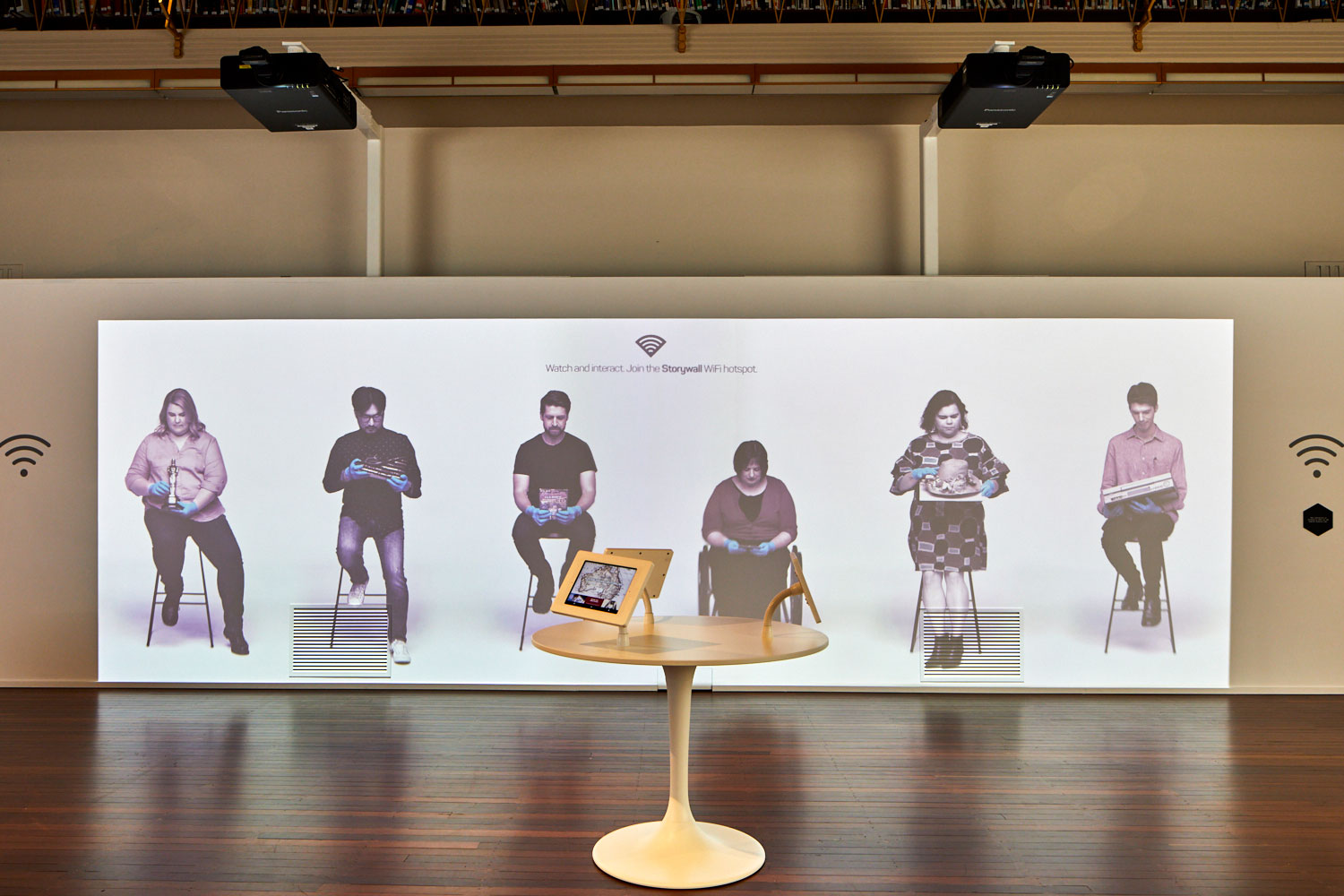 An image of six people projected onto a wall in The Hive at the NFSA.