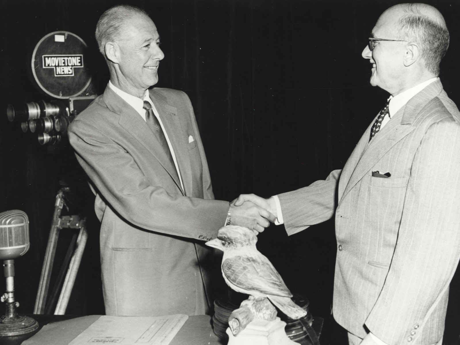 Two middle-aged men in suits shaking hands.