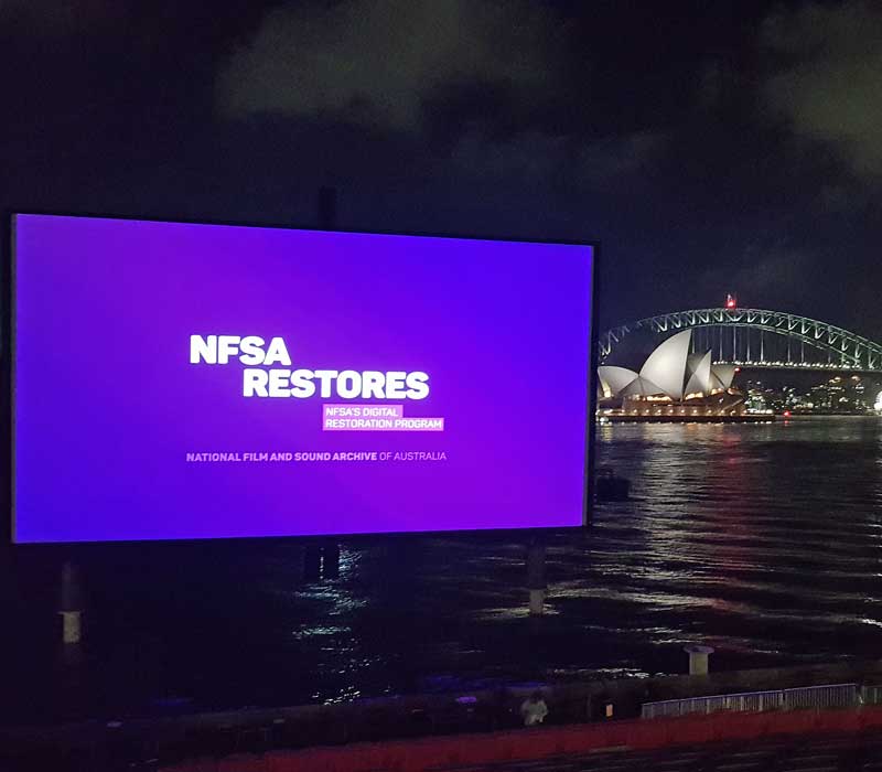 An outdoor cinema screen with the Sydney Opera House in the background
