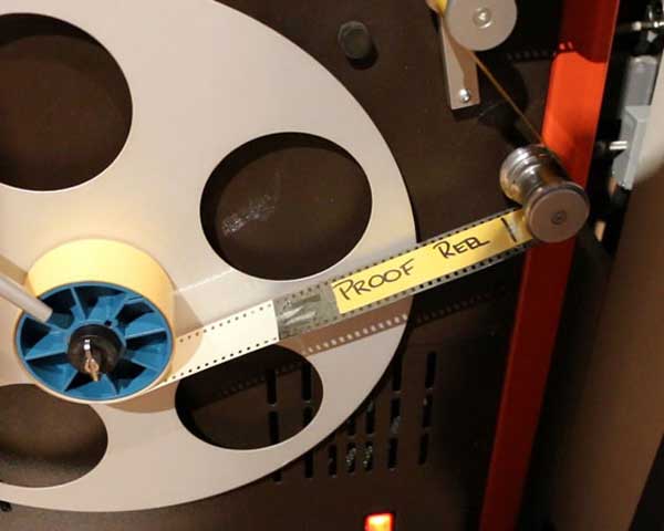 A reel of film going through a scanner.