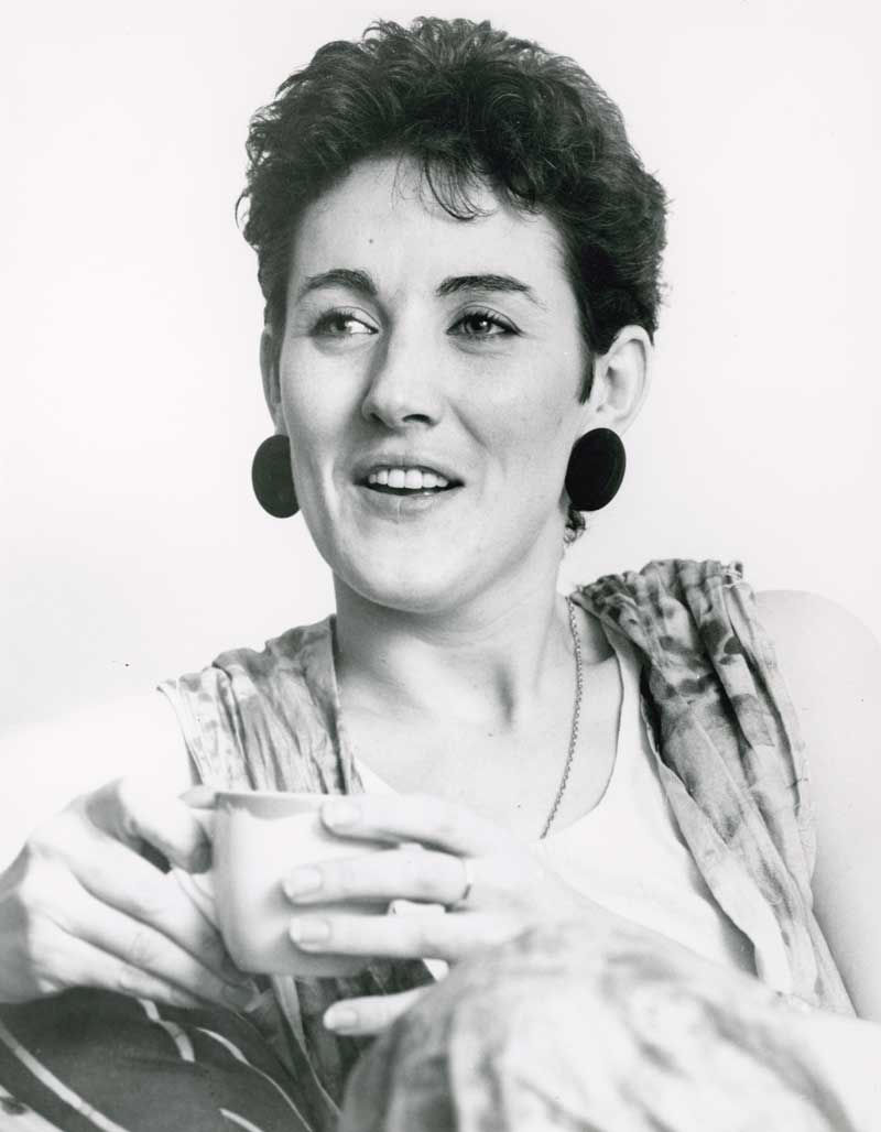 Head and shoulders shot of singer Grace Knight looking slightly away from camera and holding a coffee cup in both hands.