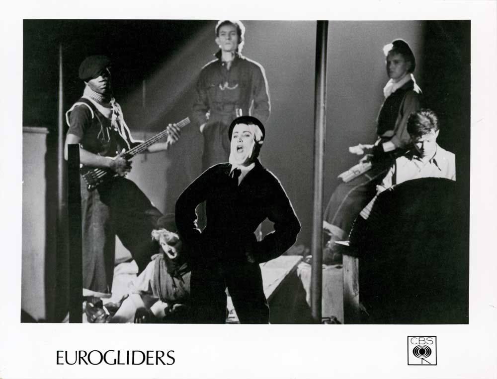 Five members of the band Eurogliders posing for a publicity photo on a stage.