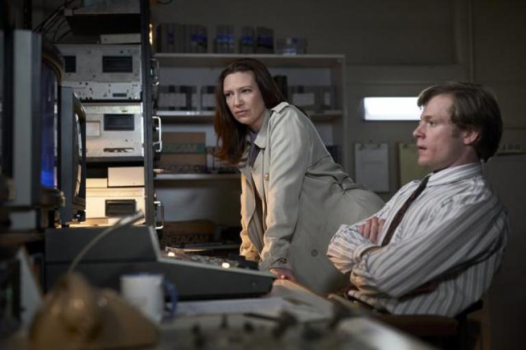 A man and woman in a TV studio control room.