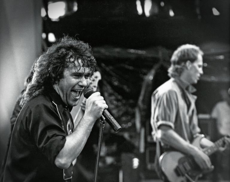 Jimmy Barnes: Australian Made Jimmy Barnes performing on stage during one of the Australian Made concerts, singing into a microphone, with a guitarist in the background.