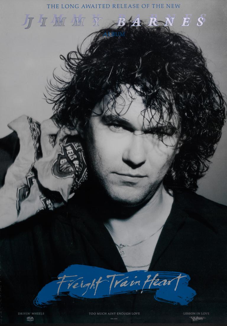 Head and shoulders shot of Jimmy Barnes looking directly at camera, pictured against a grey background on a poster for the album 'Freight Train Heart'. His name is written at the top and the album name at the bottom.