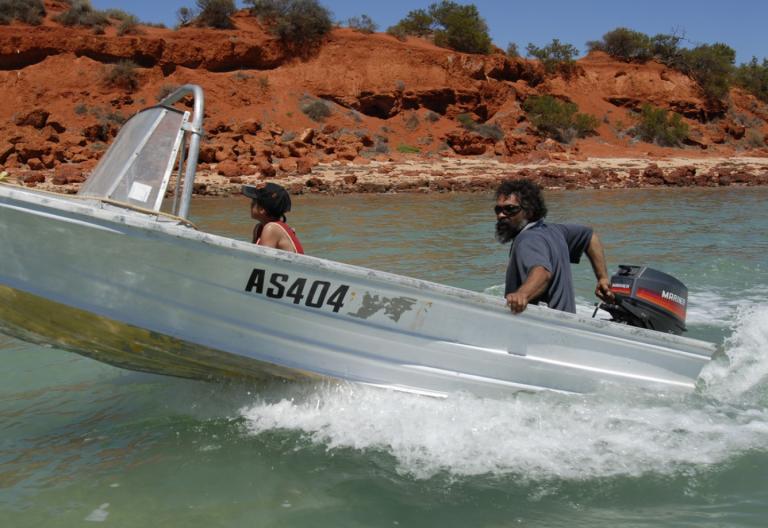 A man and boy in a motorboat on a river