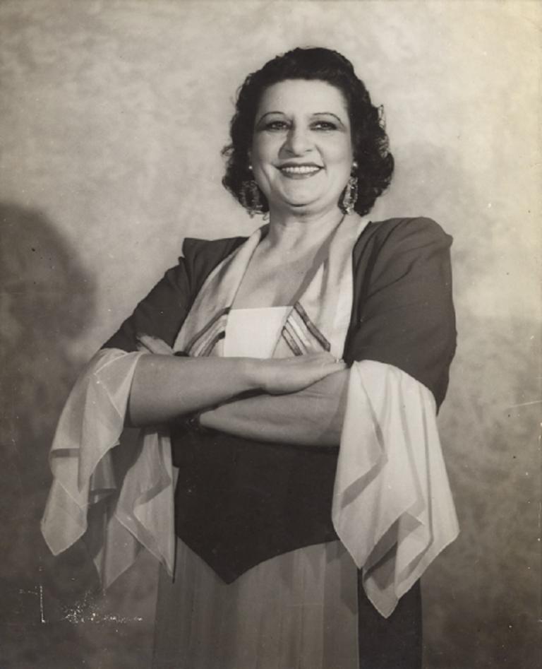 Gladys Moncrieff standing with arms folded.