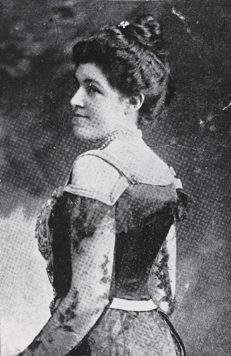 Marie Narelle standing and looking over her shoulder.