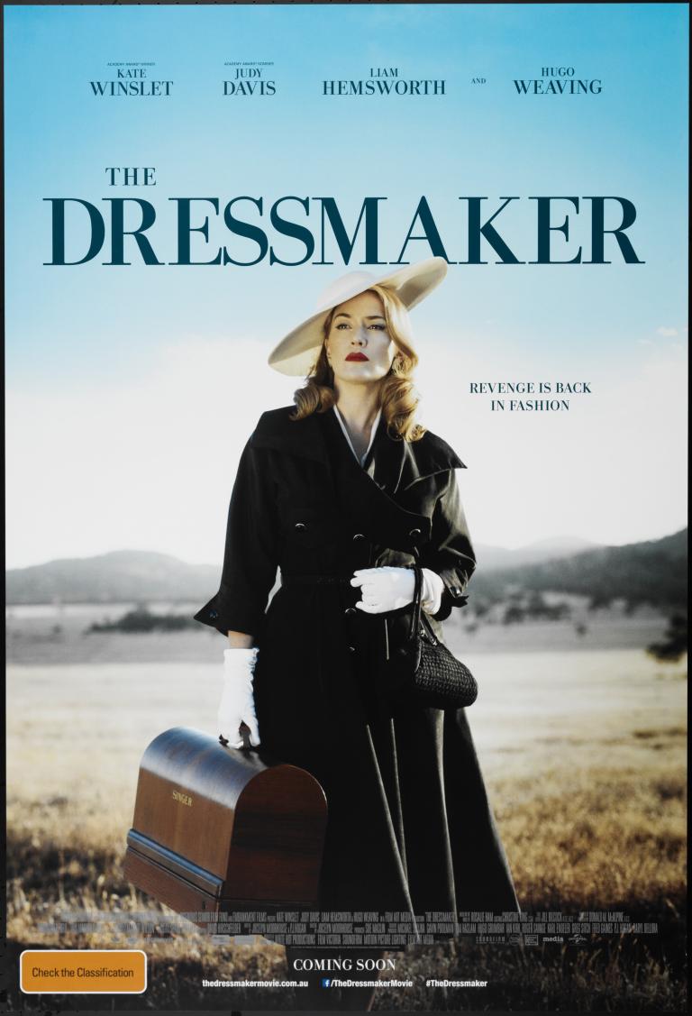 Movie poster for 'The Dressmaker' featuring Kate Winslet holding a Singer sewing machine standing in a paddock with blue sky in the background. Title is in dark blue along top and credits are in white text at bottom.