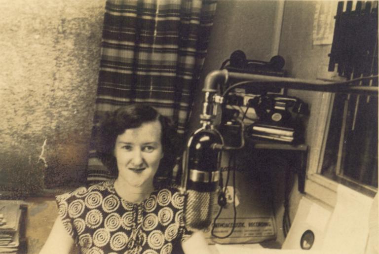 Enid Hogan behind a microphone in a radio studio