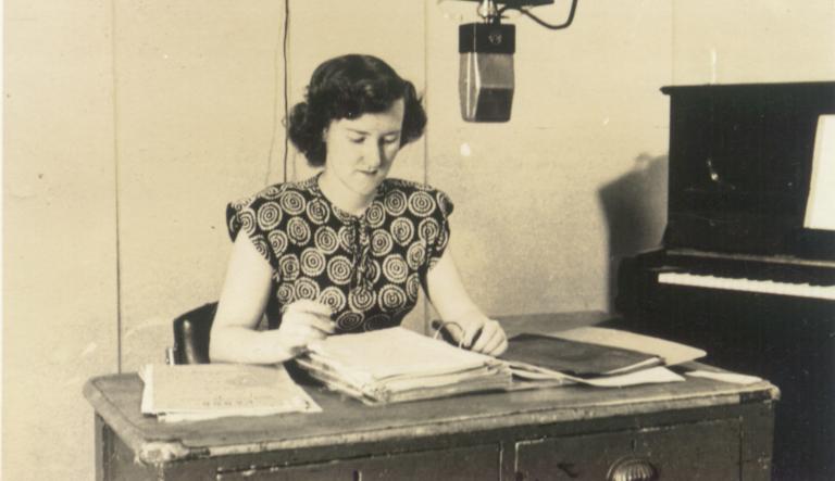 Enid Hogan behind a microphone in a radio studio