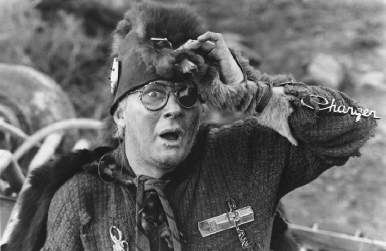 Startled looking man wearing a strange animal pelt hat.