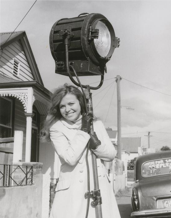 Jacki Weaver smiling with arms around a production light during the filming of Homicide