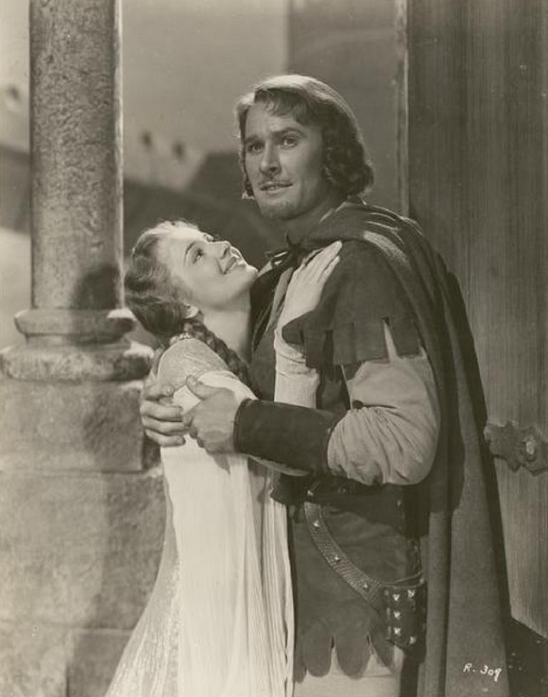 Errol Flynn and Olivia de Havilland embrace.