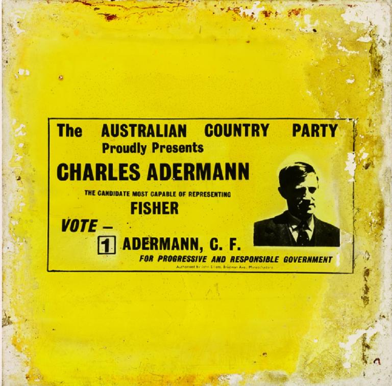 Glass slide comprising yellow background, black text in centre and left with upper body black and white photographic image of Charles Adermann to the right.