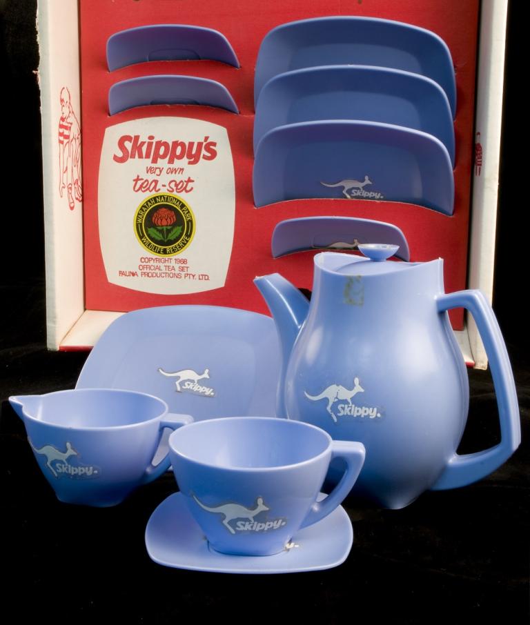 Blue plastic tea set with kangaroo motif in red cardboard box. 'Skippy Tea Set' logo on box.