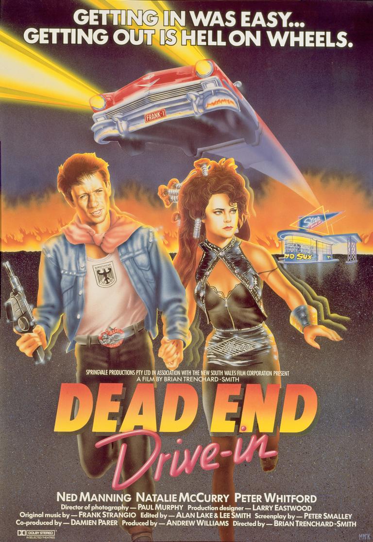Dead End Drive-In Movie Poster Poster art for the film Dead End Drive-In show a young man holding a machine gun and woman running away from a drive-in cinema. There is a red car with headlights on hovering above their heads. The film title and credits are at the bottom.
