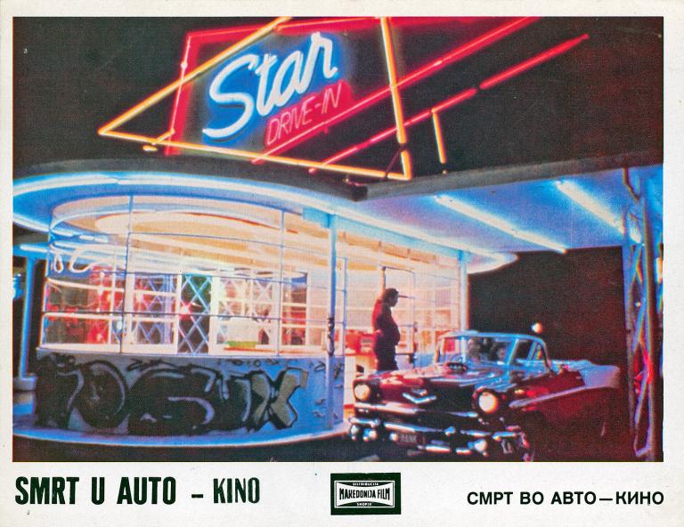 Dead End Drive-In Yugoslavian Lobby Card A graffitied driveway and reception window of a drive-in movie cinema with a neon sign on top that says "Star Drive-In". A red convertible car is in the driveway and a man is standing beside the car.