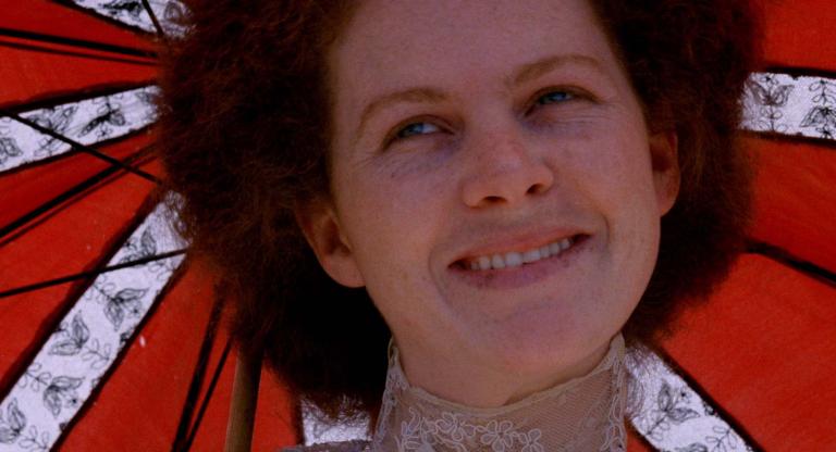 A close-up of Judy Davis smiling under a parasol in My Brilliant Career