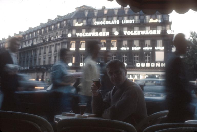 Graham Kennedy seated at an outside cafe in Paris enjoying a drink
