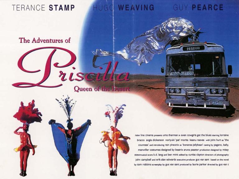 Image of bus travelling across desert with drag queen on top in large, flowing silver costume. Three drag queens in bottom left hand corner.
