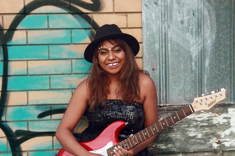 Emily Wurramara Portrait of Emily Wurramara holding an electric guitar.
