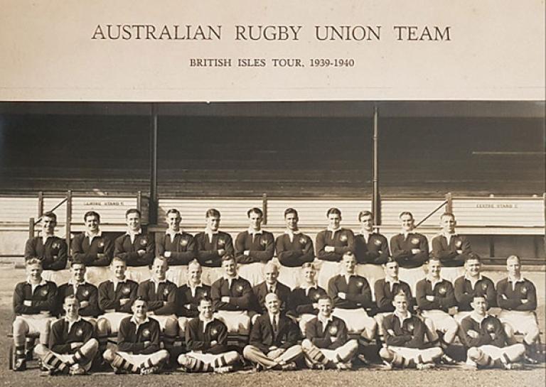 Image of a rugby team posing in three rows for a photograph 