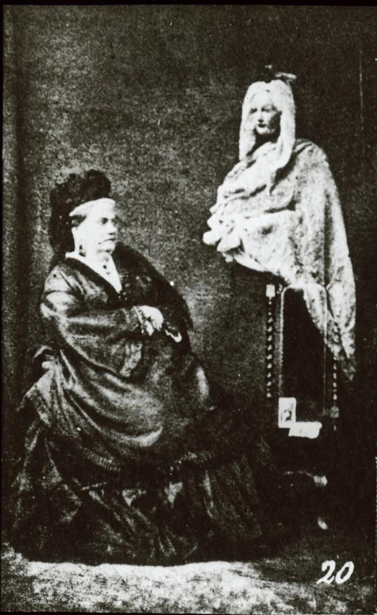 Spirit glass slide by Frederick Hudson Glass slide image of a seated finelt dressed older woman with a ghost figure hovering to her left