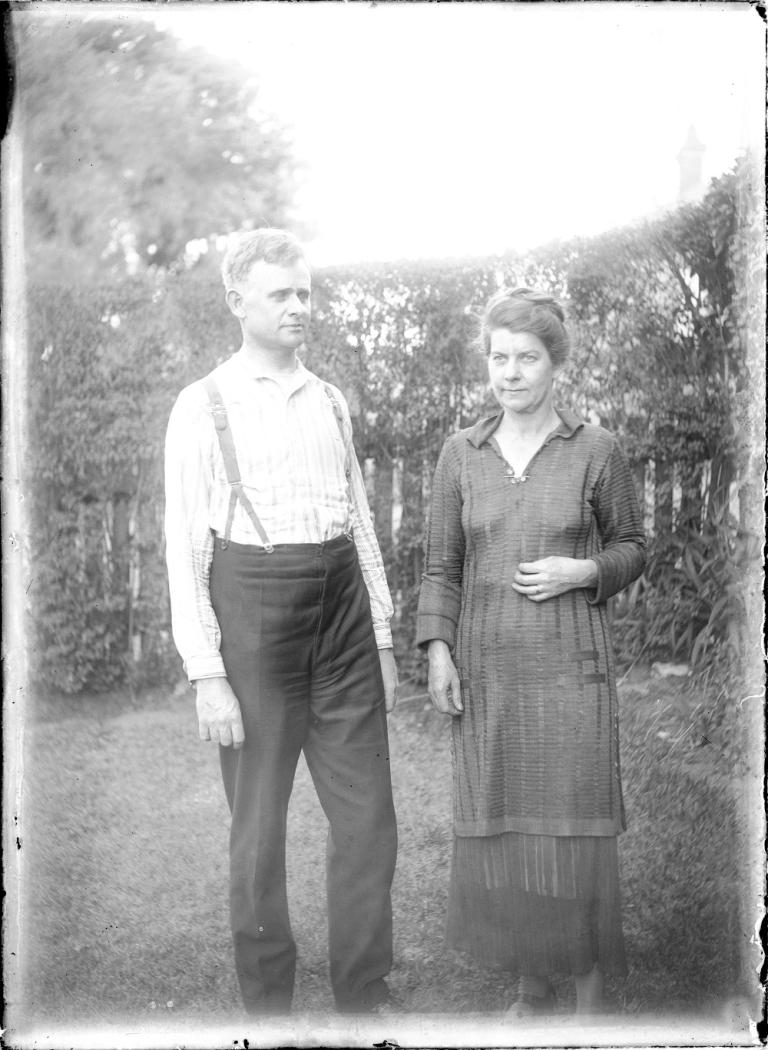 Glass negative of Stuart Booty with his wife in a garden.