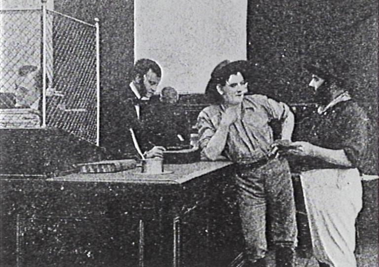 The Loyal Rebel film still Film still from the film The Loyal Rebel of a miner leaning against the counter in a bank talking to a friend