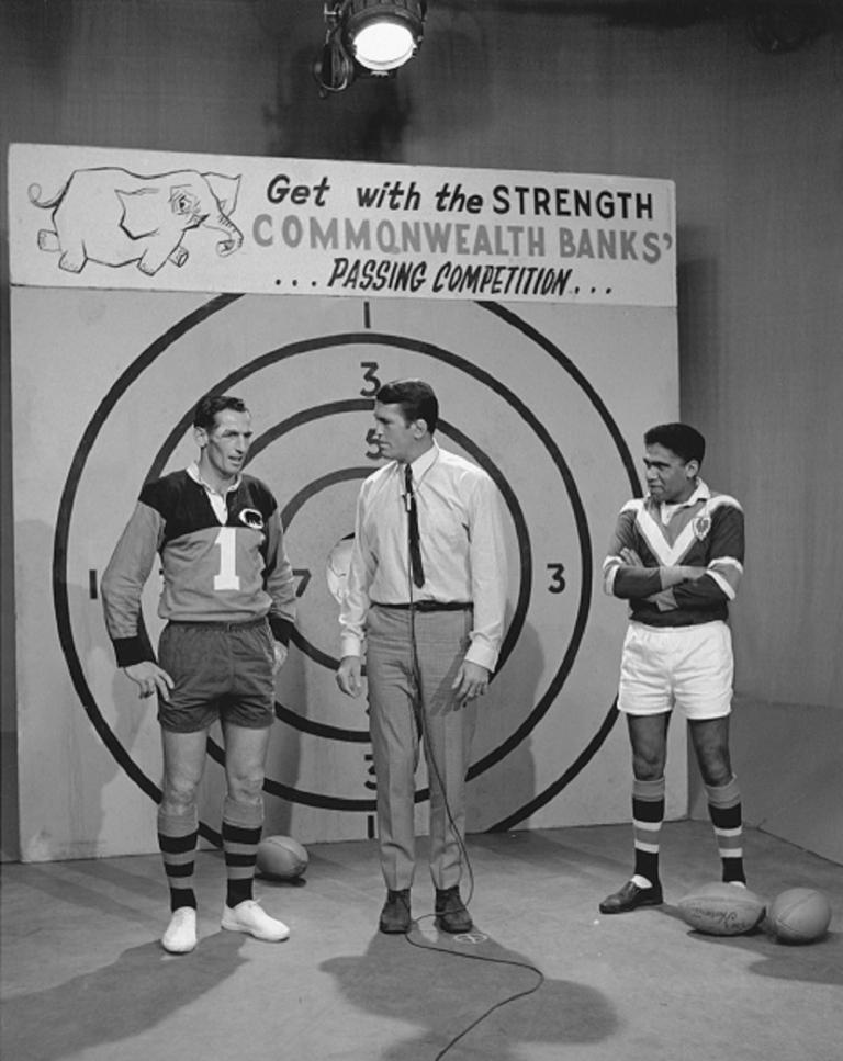 The Rugby League Show Black and white photo on set of The Rugby League Show with Rex Mossop centre, Ken Irvine to his right and Bruce Stewart on his left in front of the pass the ball competition taget.