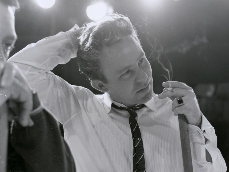 Johnny O'Keefe close up, smoking with broom in hand