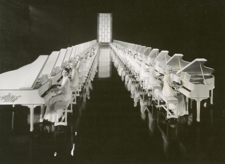 Women play pianos in two parallel rows during a musical sequence from the film Gold Diggers of 1935.