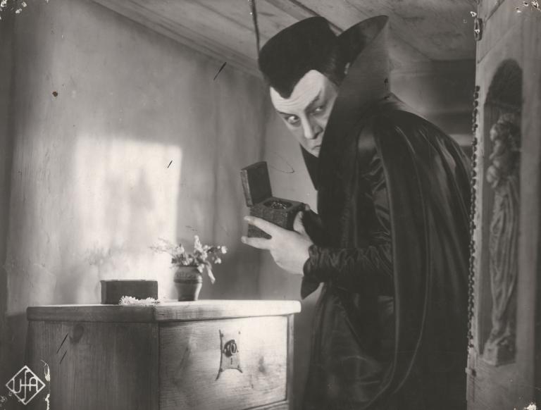 Emil Jannings as Faust clutches a small wooden box to his chest in a still from the German film Faust, 1926.