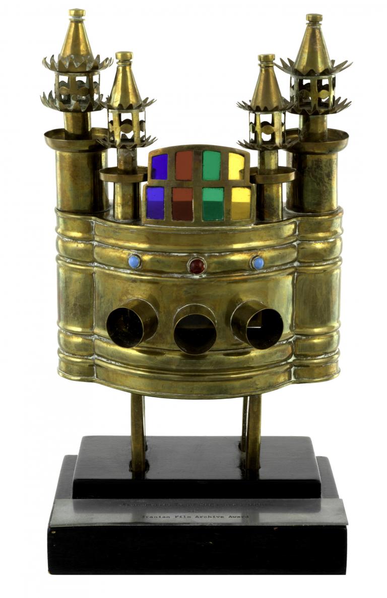 Storm Boy - Tehran award Brass trophy consisting of four legs, a hollow mid section (with door at rear) and three portals at front, four decorative turrets at top and at centre top, a stained glass feature. Also features a painted wooden base with an aluminium plaque