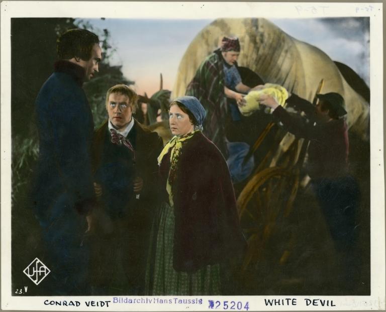 Had coloured black and white print shwoing a tall man looking down at a peasant couple with a covered wagon behind them