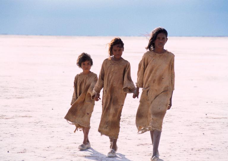 Tianna Sansbury as Daisy, Laura Monaghan as Gracie and Everlyn Sampi as Molly walking hand in hand across a salt flat.