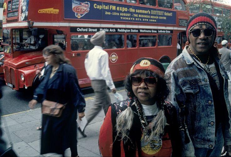 Archie Roach and Ruby Hunter in London A photograph of Archie Roach and Ruby Hunter standing on a busy street in London. People walk behind them and there is a red double decker bus in the background.