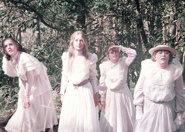 The four schoolgirls look up while climbing the rock