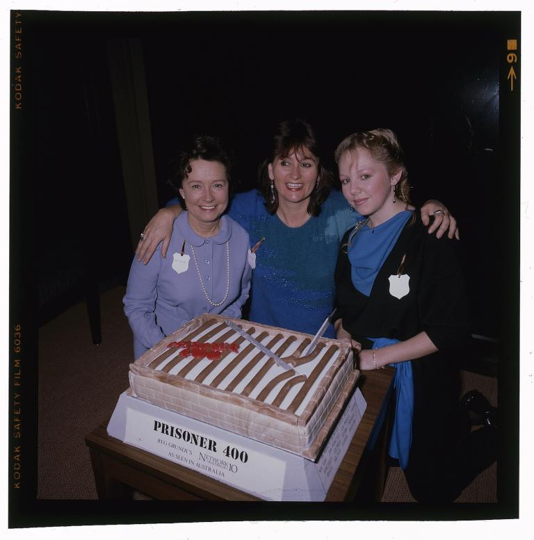 Prisoner 400th episode cake Three members of the cast of Prisoner posing with a decorated cake. A label reads 'Prisoner 400. Reg Grundy's. Network 10 Australia. As seen in Australia'.