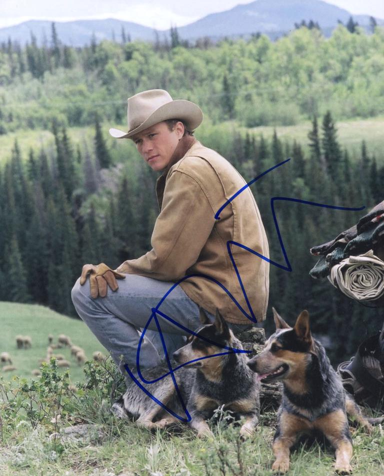Ennis Del Mar - Brokeback Mountain Heath Ledger in a hat and jacket as farm hand Ennis Del Mar from the film Brokeback Mountain. There are mountains and rolling hills and trees in the background.