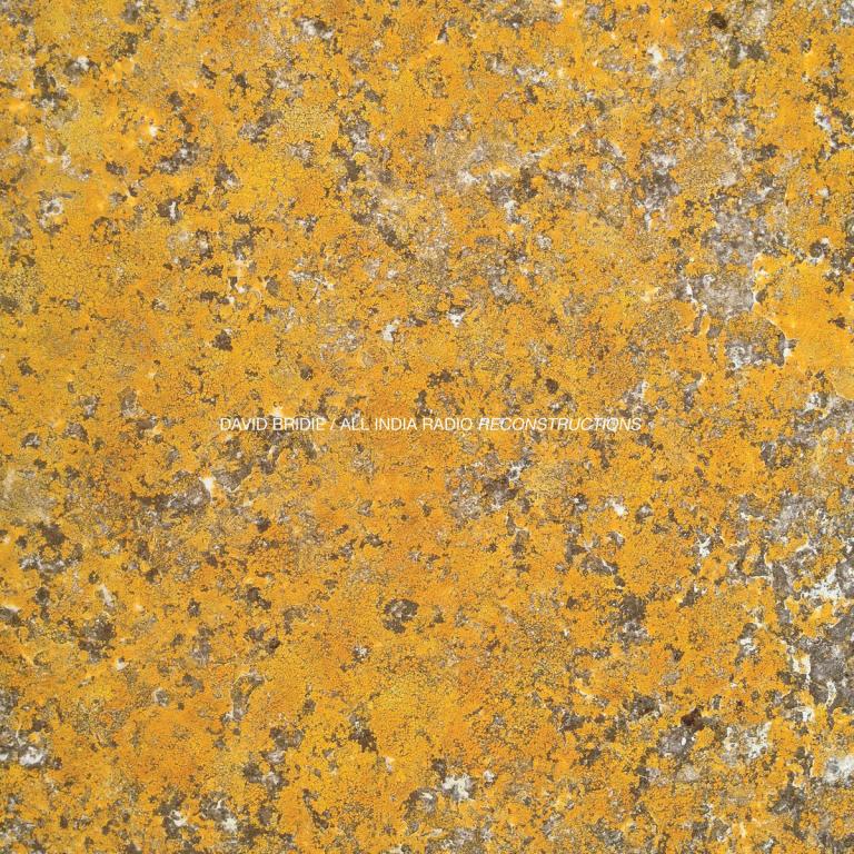An album cover with a speckled, marbled, yellow gold design on it.