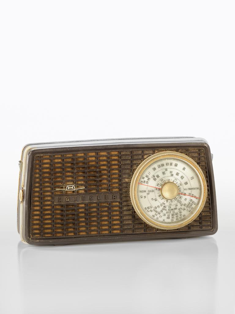 A small portable radio from the 1960s with a dial on the front and in-built speaker