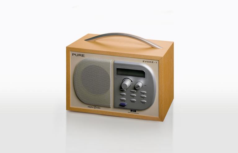 Evoke brand radio receiver in a rectangular wooden casing with a handle on top.