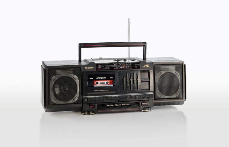 A rectangular black portable radio and cassette recorder from the 1980s with speakers on either end and a tape deck in the middle.