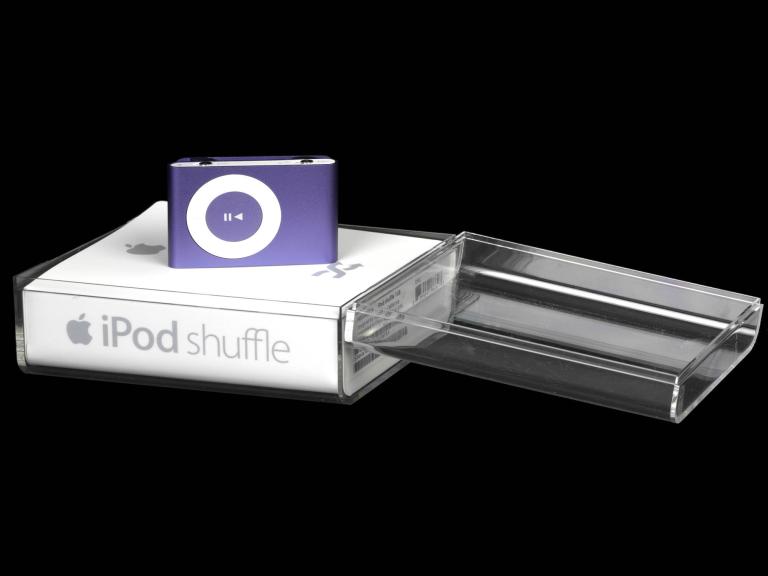 A photo of a blue iPod shuffle sitting in its white Apple branded packaging case. 