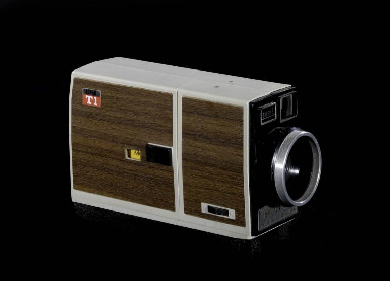 A photo of a small handheld camera. It has dark brown timber paneling and grey plastic trims. 