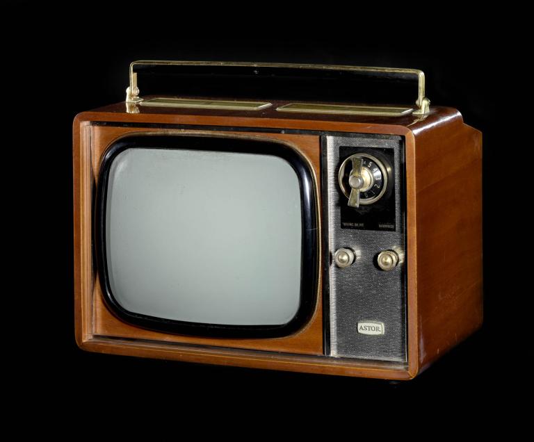 A photo of a television with a wooden veneer. It has a silver panel on the side with 3 dials. On top of the set there is a handle. 